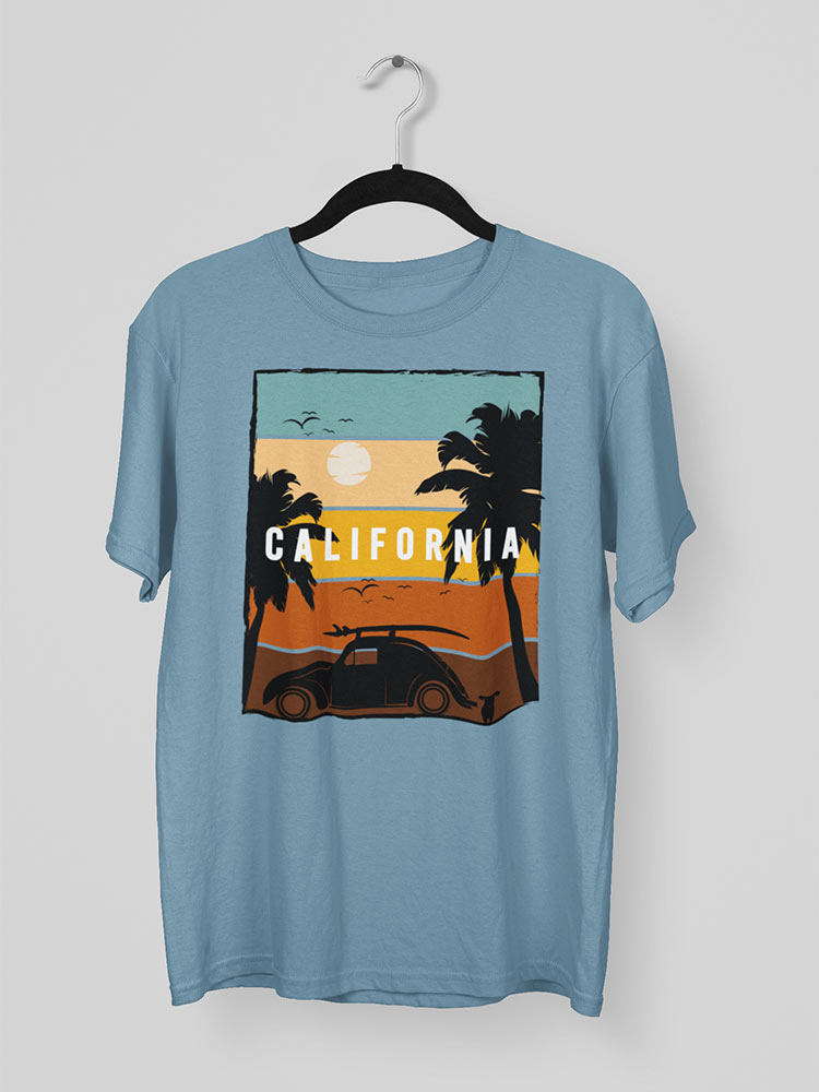 A light blue t-shirt with a graphic of a sunset, palm trees, a vintage car, and the word "CALIFORNIA" hangs on a white background.