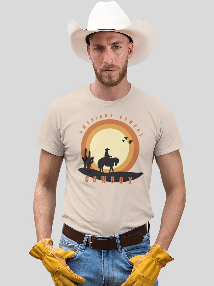 A person wearing a cowboy hat, a T-shirt with a cowboy graphic, blue jeans, a belt, and holding yellow gloves. They have a serious expression.