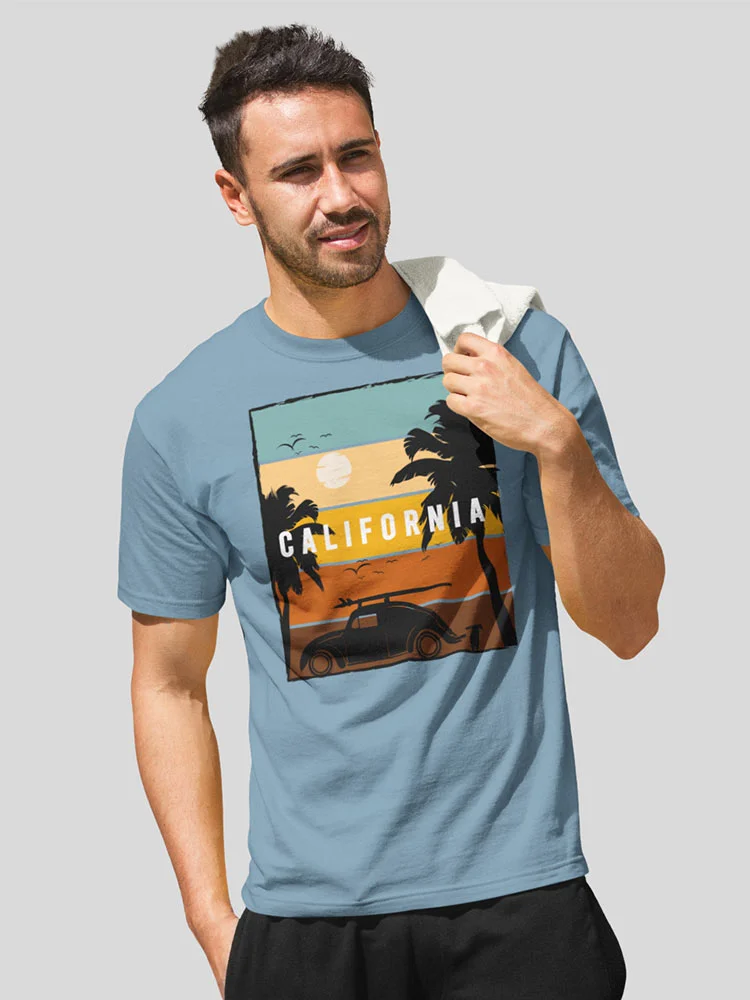 A person in a blue t-shirt with a "California" graphic, holding a towel, squinting slightly, against a neutral background.