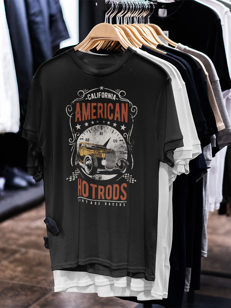 A collection of t-shirts on wooden hangers displayed in a store. The prominent shirt features a vintage car and text, "American Hotrods," with a retro design.