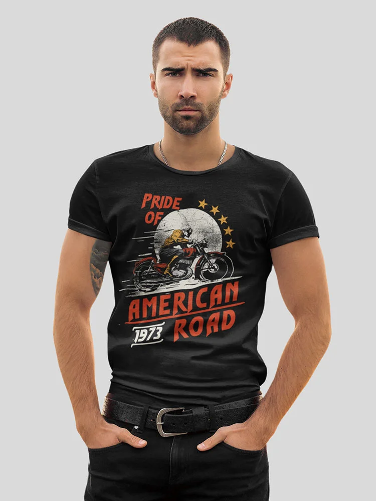A person is posing in a black t-shirt with a motorcycle print, labeled "Pride of American Road 1973," against a gray background.