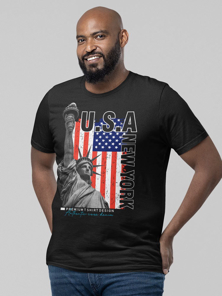 A smiling person wearing a black T-shirt with a patriotic USA and New York theme, including the Statue of Liberty and an American flag.