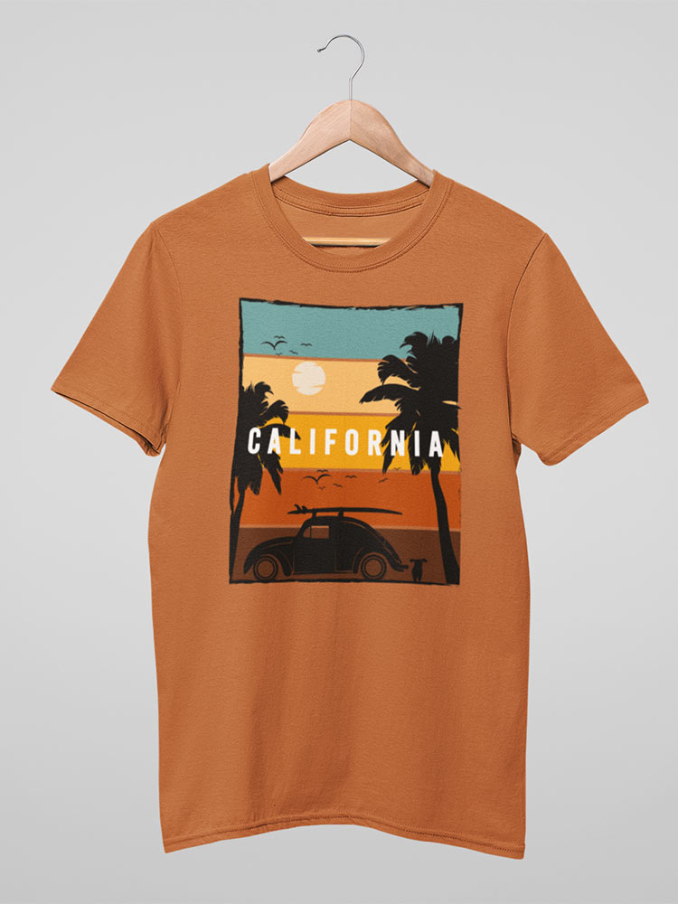 A brown T-shirt hanging on a hanger with a graphic of a sunset, palm trees, a car, and the word "CALIFORNIA" displayed across the design.