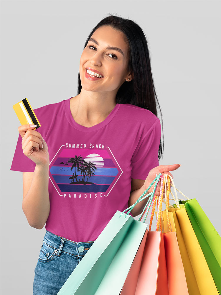 A smiling person holding colorful shopping bags in one hand and a credit card in the other, wearing a pink "Summer Beach Paradise" t-shirt.