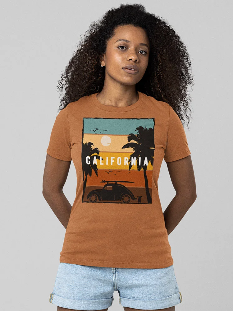 A person is standing, wearing a brown T-shirt with a "California" beach graphic and blue denim shorts, against a neutral background.